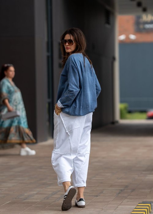 Niebieska bluza oversize w odcieniu denimu z białym ściągaczem przy dekolcie, luźny fason, miejska stylizacja damska.