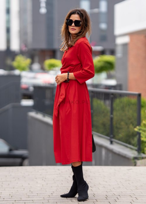 Czerwona sukienka maxi z kopertową górą, kołnierzykiem i wiązaniem w talii. Kobiecy model z kieszeniami i rękawem 3/4 prezentowany na modelce.