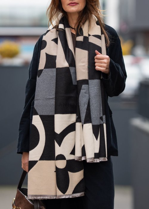 Stylizacja jesienna: beżowa czapka beanie z naszywką uśmiechu oraz duży szalik w beżowo-czarny wzór graficzny, połączone z szarą bluzą oversize i jeansami