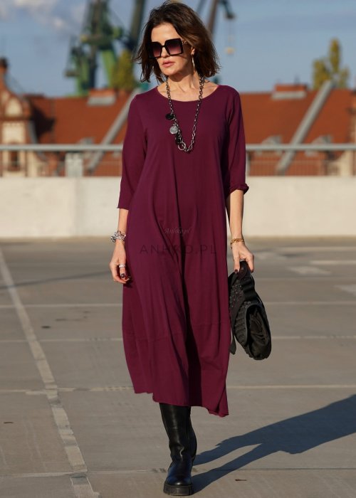 Purpurowa sukienka maxi z rękawem 3/4 i delikatną bombką u dołu, wykonana z bawełny, stylizowana z czarnymi kozakami w miejskim looku.