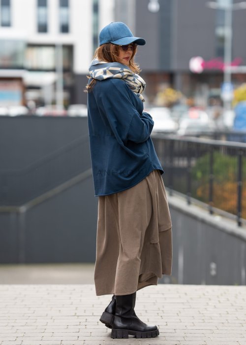 Ciemnoniebieska bluza damska oversize z długim rękawem i naszywką na froncie. Luźny fason w miejskiej stylizacji z czapką i spódnicą.