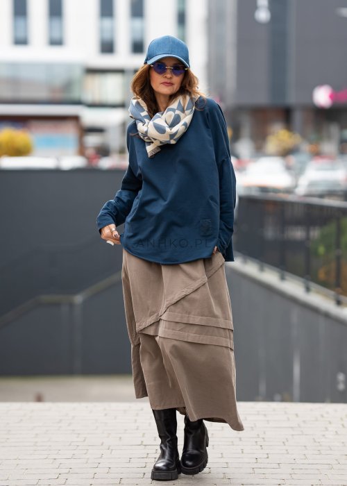 Ciemnoniebieska bluza damska oversize z długim rękawem i naszywką na froncie. Luźny fason w miejskiej stylizacji z czapką i spódnicą.
