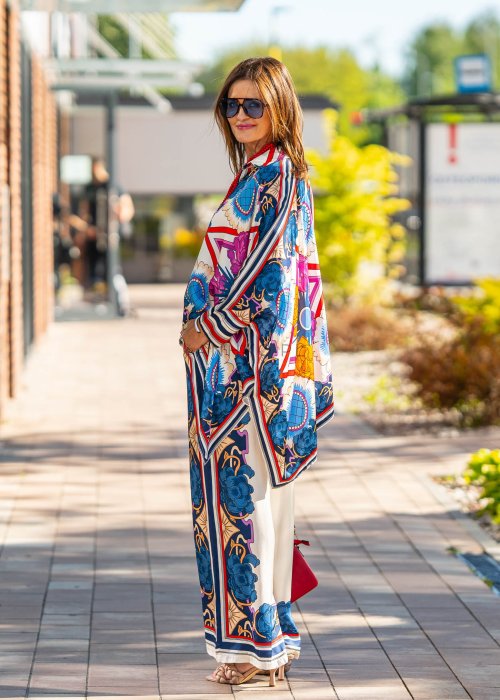 Jasne spodnie damskie z szeroką nogawką, zdobione kolorowym kwiatowym nadrukiem w stylu boho
