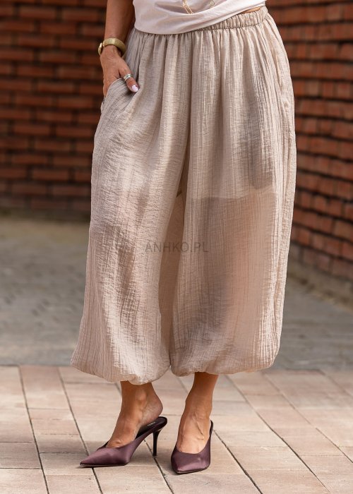 Beżowe spodnie damskie z muślinu, szerokie nogawki 7/8, lekki materiał, styl boho, elastyczna talia, letnia stylizacja