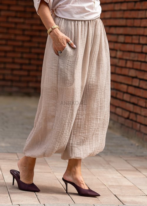 Beżowe spodnie damskie z muślinu, szerokie nogawki 7/8, lekki materiał, styl boho, elastyczna talia, letnia stylizacja