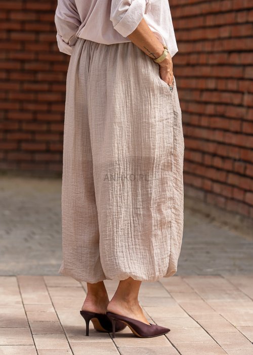 Beżowe spodnie damskie z muślinu, szerokie nogawki 7/8, lekki materiał, styl boho, elastyczna talia, letnia stylizacja