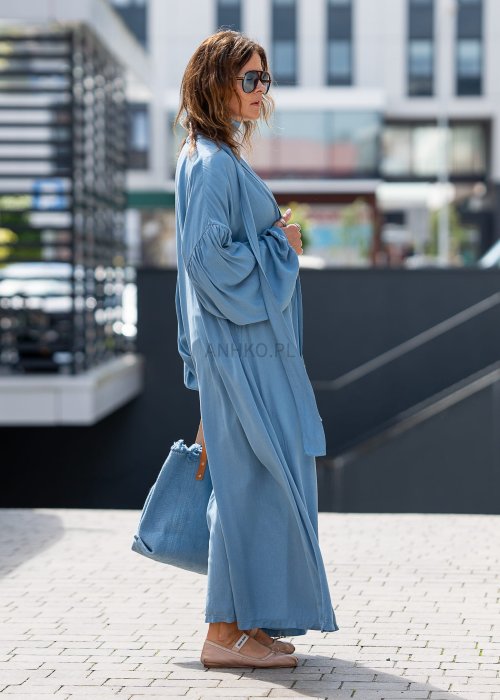 Niebieskie kimono damskie maxi o długim, lejącym fasonie z bufiastymi rękawami. Stylizacja z białym topem i jeansami w miejskim, casualowym wydaniu.