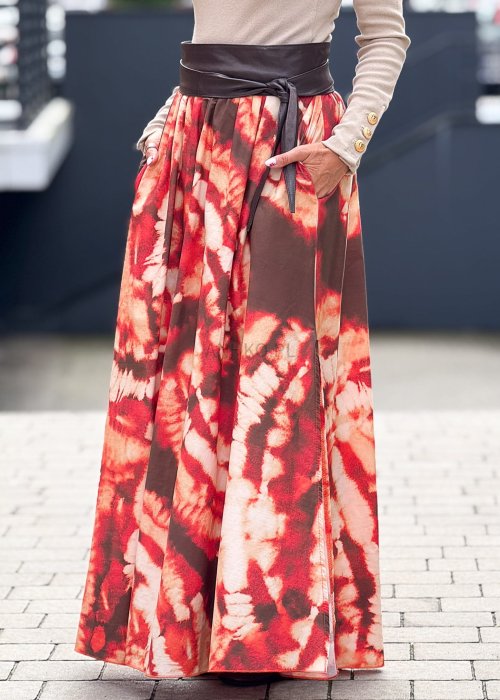 Długa spódnica maxi w stylu boho, wzór tie-dye w odcieniach czerwieni i brązu, rozkloszowany krój z szerokim paskiem