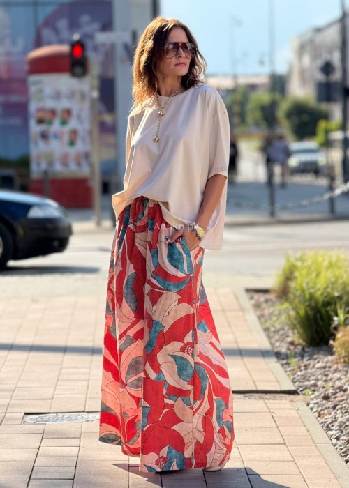 Szerokie spodnie damskie palazzo z wysokim stanem, wzór w duże kwiaty w odcieniach czerwieni, beżu i turkusu, styl boho