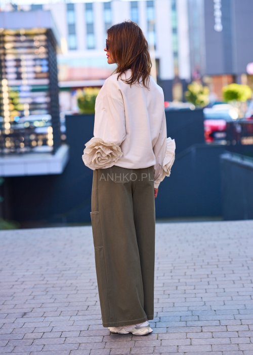 Luźne, szerokie spodnie w kolorze khaki o casualowym charakterze. Model z wysokim stanem, zapinany na duże, ozdobne guziki przesunięte lekko na bok, co nadaje im oryginalności.