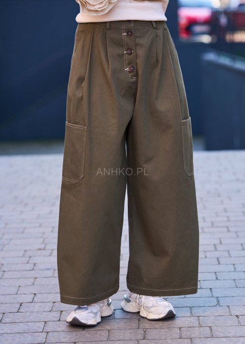 Luźne, szerokie spodnie w kolorze khaki o casualowym charakterze. Model z wysokim stanem, zapinany na duże, ozdobne guziki przesunięte lekko na bok, co nadaje im oryginalności.