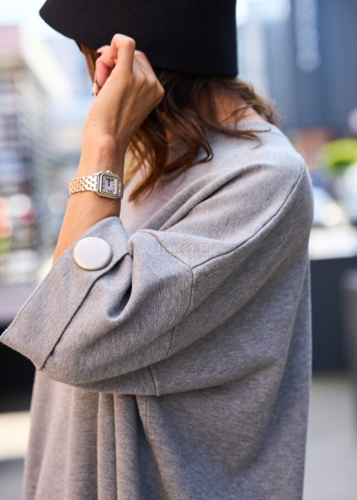 Szary oversize sweter damski z długim rękawem i ozdobnym guzikiem, minimalistyczna moda codzienna