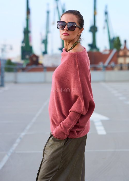 Różowy sweter damski oversize z szerokim dekoltem opadającym na ramię, stylowa elegancja casual