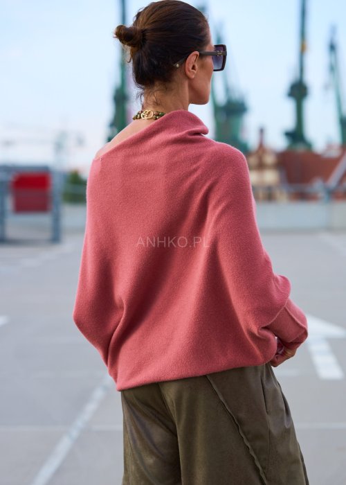Różowy sweter damski oversize z szerokim dekoltem opadającym na ramię, stylowa elegancja casual