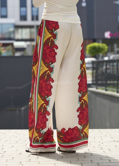 Szerokie spodnie damskie z lekkiego materiału w kolorze ecru z czerwonym kwiatowym i geometrycznym printem boho