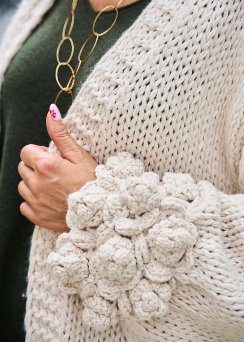 Kremowy kardigan handmade gruby, dziergany sweter z luźnym fasonem i ozdobnymi rękawami.