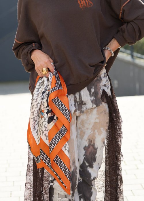 Jedwabna chusta damska we wzory geometryczne i motywy graficzne z pomarańczową ramką, elegancki dodatek w stylu boho