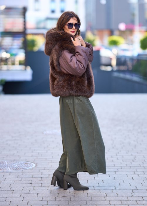 Spódnica maxi w kolorze khaki z elastyczną talią i kieszeniami, o luźnym kroju, zestawiona z wzorzystą bluzką i botkami na słupku w miejskiej stylizacji.