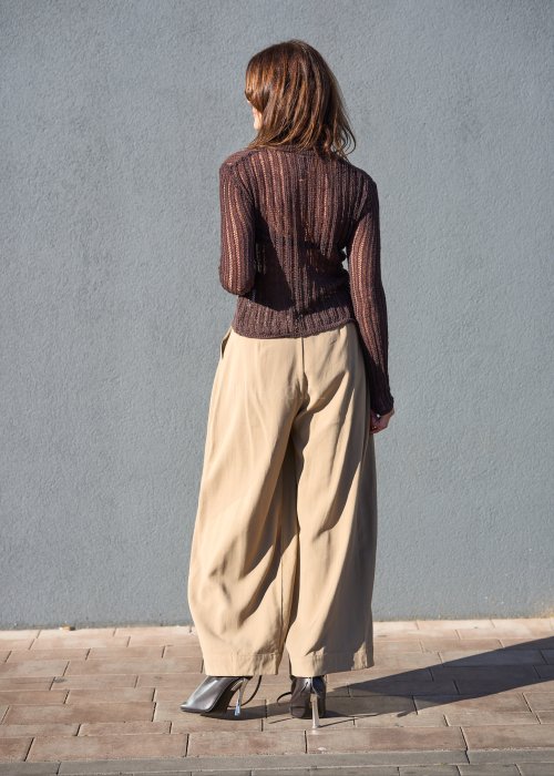 Luźne spodnie w kolorze beżowym, o szerokich nogawkach i miękkiej linii, wykonane z przewiewnego materiału, idealne do stylizacji casual i boho.