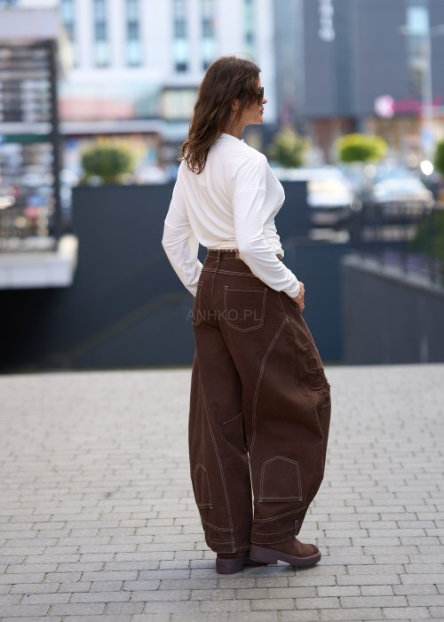 Biała, dopasowana bluzka damska z długim rękawem i półgolfem, wykonana z elastycznego materiału o gładkiej strukturze, tworząca elegancki, minimalistyczny look