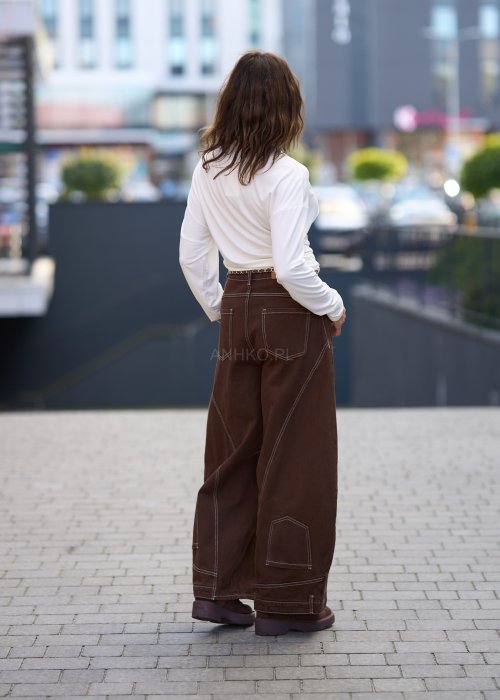 Biała, dopasowana bluzka damska z długim rękawem i półgolfem, wykonana z elastycznego materiału o gładkiej strukturze, tworząca elegancki, minimalistyczny look