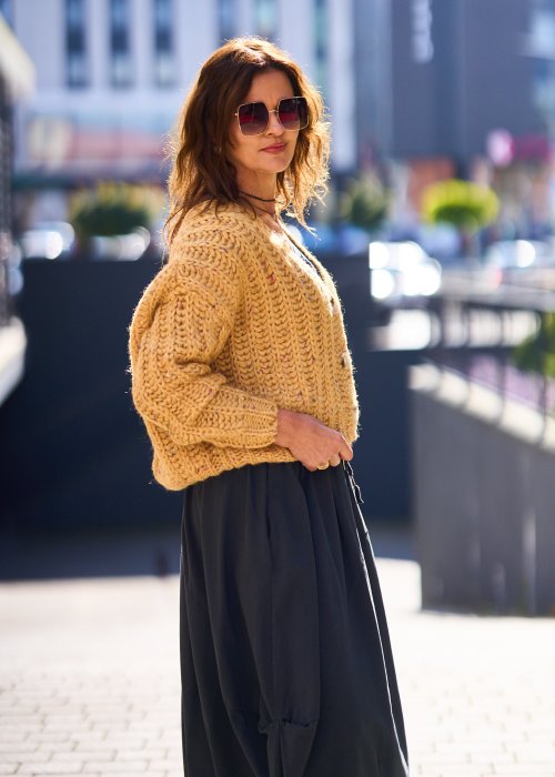 Żółty kardigan damski z grubym splotem, zapinany na duże guziki, o krótszym kroju i luźnym fasonie, styl casual boho
