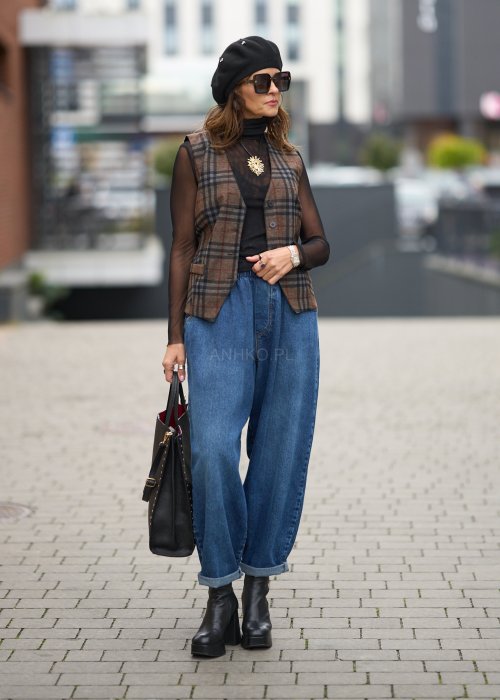 Niebieskie jeansy damskie o kroju slouchy z elastycznym pasem i podwiniętą nogawką. Stylizacja z botkami na obcasie w miejskim, casualowym stylu.