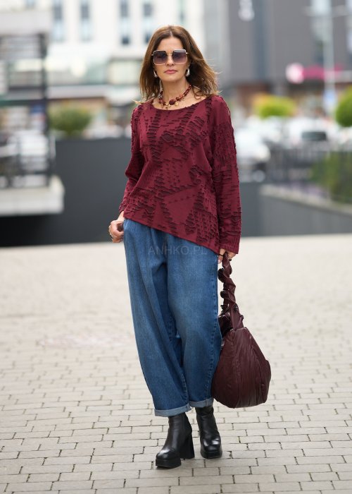 Niebieskie jeansy damskie o kroju slouchy z elastycznym pasem i podwiniętą nogawką. Stylizacja z botkami na obcasie w miejskim, casualowym stylu.