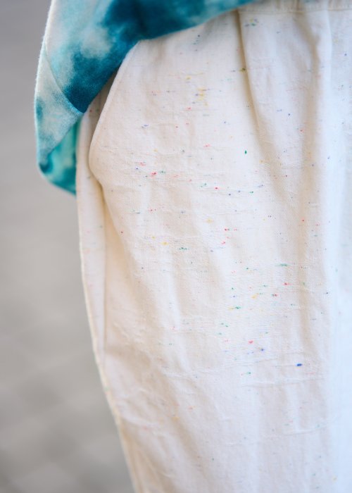 Kremowe spodnie z naturalnej tkaniny, luźna nogawka, elastyczny pas i swobodny fason w stylu boho