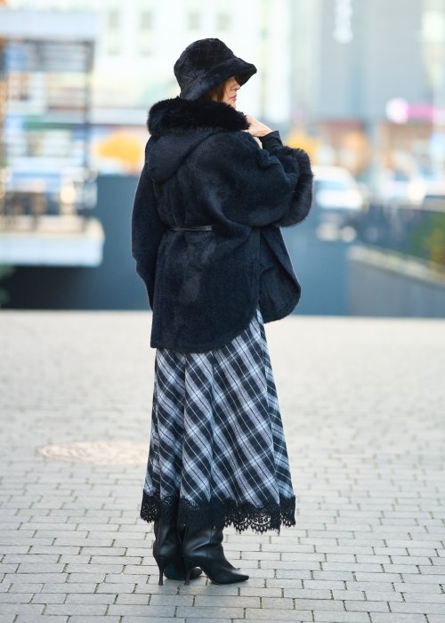 Ciepły czarny płaszcz z futrzanym kołnierzem i mankietami przewiązywany satynowym paskiem elegancka moda damska