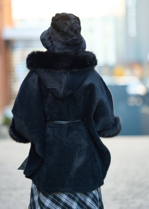 Ciepły czarny płaszcz z futrzanym kołnierzem i mankietami przewiązywany satynowym paskiem elegancka moda damska