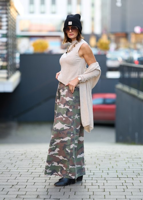 Szerokie spodnie damskie w militarny wzór moro z wysokim stanem i zakładkami w pasie, w stylizacji z paskiem i sneakersami.