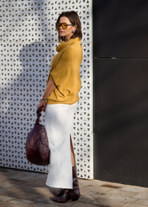 Sweter oversize w kolorze musztardowym z szerokim kołnierzem typu komin i luźnym krojem poncza. Model w stylizacji miejskiej, podkreślający miękką dzianinę i swobodny fason.