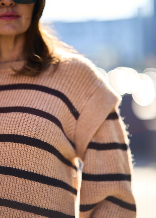 Beżowy sweter oversize w czarne pasy z grubej dzianiny, luźny krój i długie rękawy w modzie damskiej