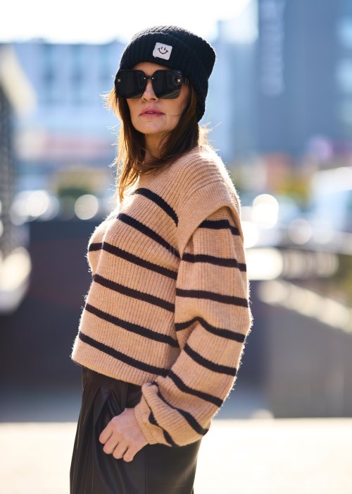 Beżowy sweter oversize w czarne pasy z grubej dzianiny, luźny krój i długie rękawy w modzie damskiej