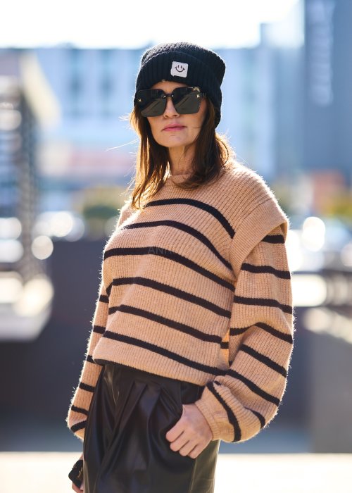 Beżowy sweter oversize w czarne pasy z grubej dzianiny, luźny krój i długie rękawy w modzie damskiej