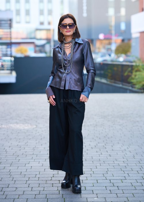 Elegancka bluzka koszulowa o dopasowanym, kobiecym kroju, wyraźnie modelującym talię. Wykonana z gładkiej, lejącej tkaniny o satynowym połysku