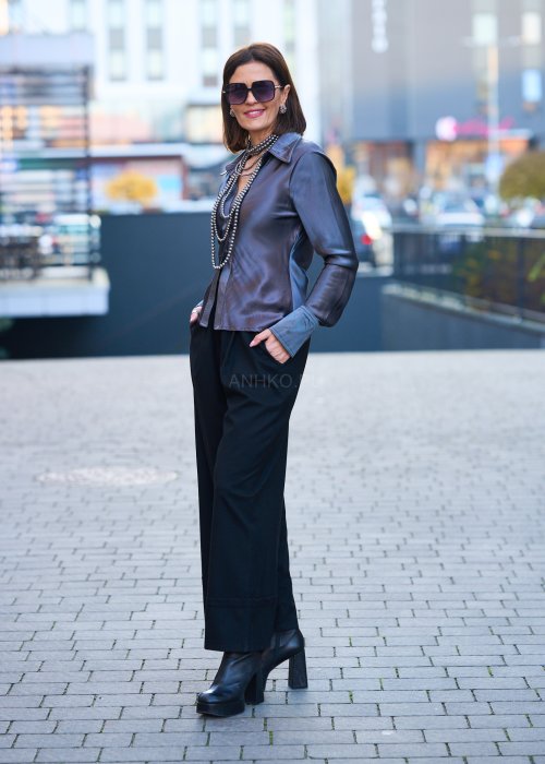 Elegancka bluzka koszulowa o dopasowanym, kobiecym kroju, wyraźnie modelującym talię. Wykonana z gładkiej, lejącej tkaniny o satynowym połysku