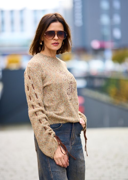 Beżowy sweter damski z napisem i ozdobnym sznurowaniem na rękawach, miękka dzianina, styl casual