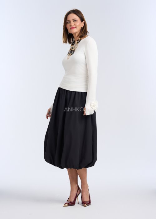 To czarna spódnica o długości midi, o balonowym fasonie. Ma luźno układającą się formę, z marszczeniem w pasie oraz ściągniętym dołem