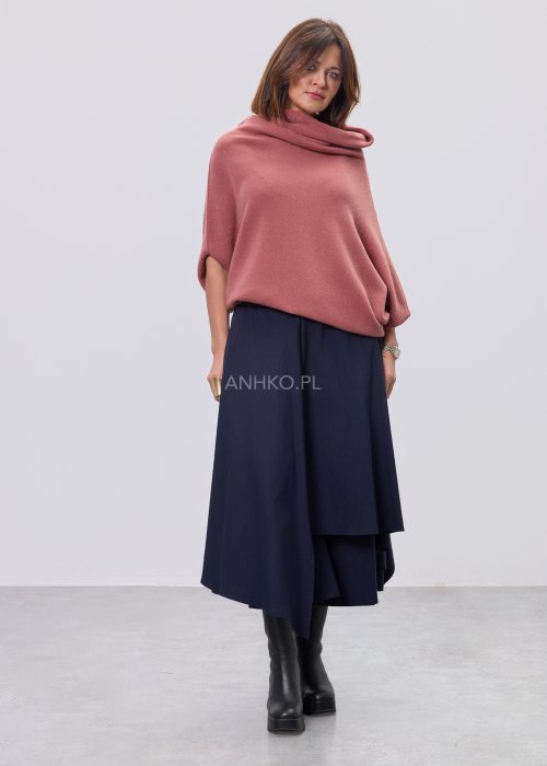 Sweter oversize w kolorze brudnego różu z szerokim kołnierzem typu komin i luźnym krojem poncza. Model prezentowany w stylizacji z ciemnym dołem, podkreślający miękką dzianinę i asymetryczny fason.