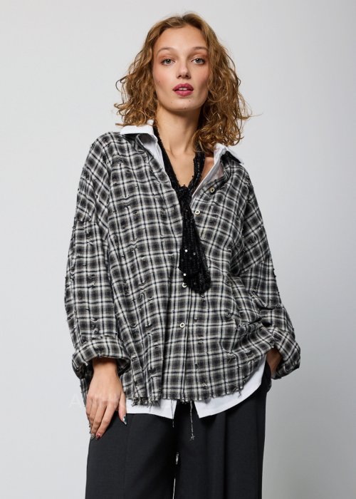 Szara koszula damska oversize w kratę z artystycznymi przetarciami i klasycznym kołnierzykiem. Bawełniany model w stylu grunge prezentowany w miejskiej stylizacji.