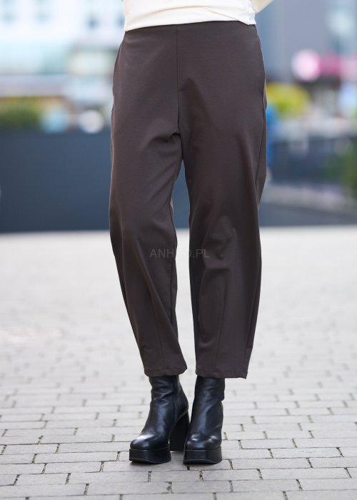 Brązowe spodnie damskie o luźnym kroju i prostej nogawce, gładki materiał, styl minimalistyczny
