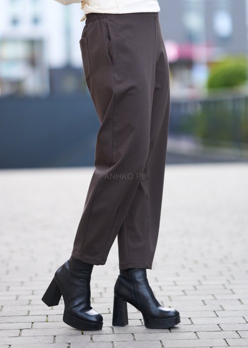 Brązowe spodnie damskie o luźnym kroju i prostej nogawce, gładki materiał, styl minimalistyczny
