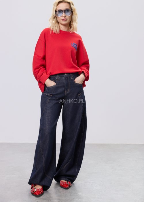 Czerwona bluza damska oversize z nadrukiem Since 1998 z przodu i okrągłą grafiką na plecach, stylizacja z szerokimi jeansami.