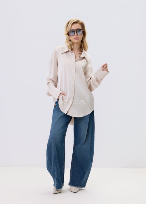 Jeansy damskie Driftline w kolorze ciemnego denimu o szerokiej nogawce i surowym wykończeniu dołu, stylizowane z jasnym topem i botkami na obcasie.