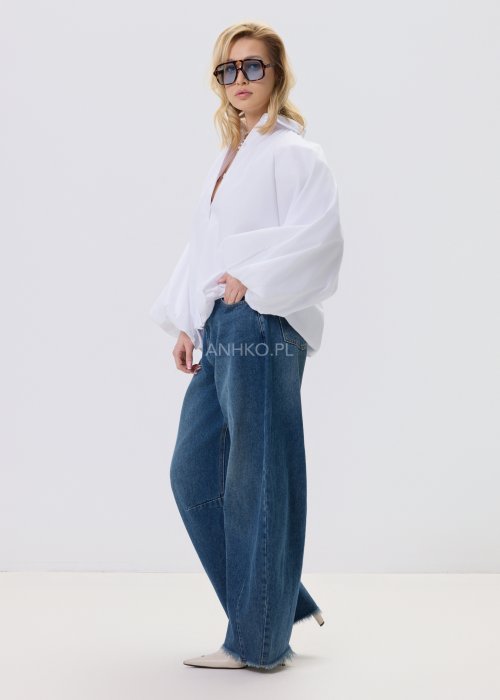 Jeansy damskie Driftline w kolorze ciemnego denimu o szerokiej nogawce i surowym wykończeniu dołu, stylizowane z jasnym topem i botkami na obcasie.
