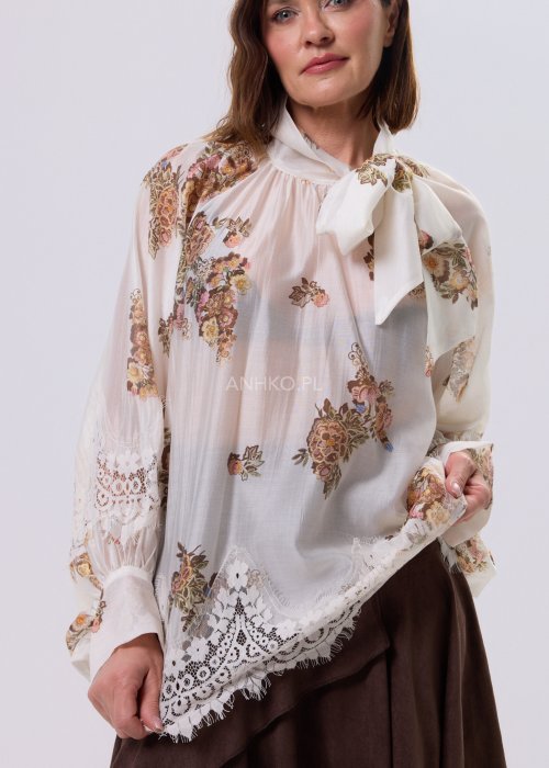 Jasnobeżowa bluzka Liora Bloom z kwiatowym nadrukiem, dekolt V-neck, luźny fason za biodra i koronkowe wykończenie w stylu boho.