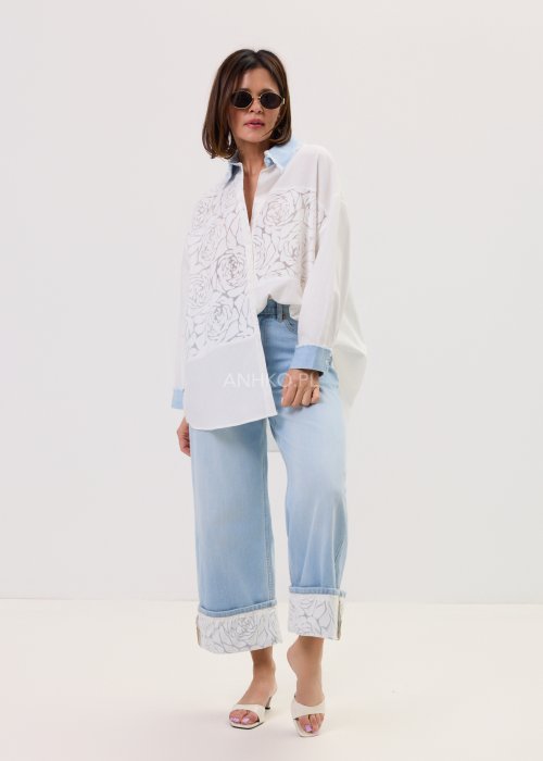 Jasnoniebieskie damskie jeansy Blue Blossom Roll z prostą, lekko skróconą nogawką i wywiniętym mankietem. Model z klasycznymi kieszeniami oraz dekoracyjnym, jasnym wzorem kwiatowym na podwinięciach i tylnych kieszeniach