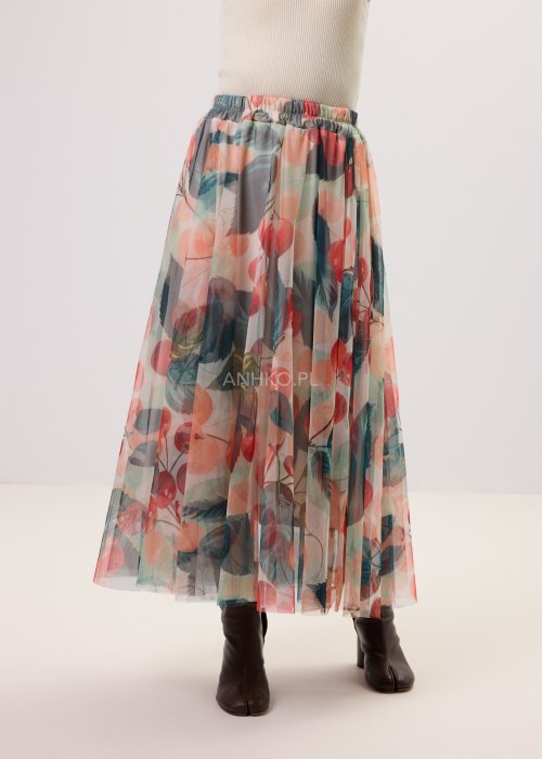 Zwiewna spódnica midi Lunareth Cherry z transparentnej tkaniny w print z wiśniami i liśćmi, z elastyczną gumką w pasie. Stylizacja z pomarańczowym swetrem i brązowymi botkami na obcasie.